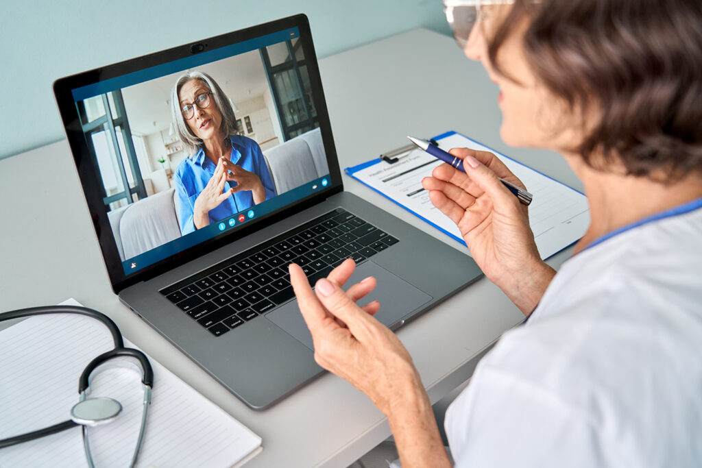Telemedicine appointment between physician and patient shown on laptop screen