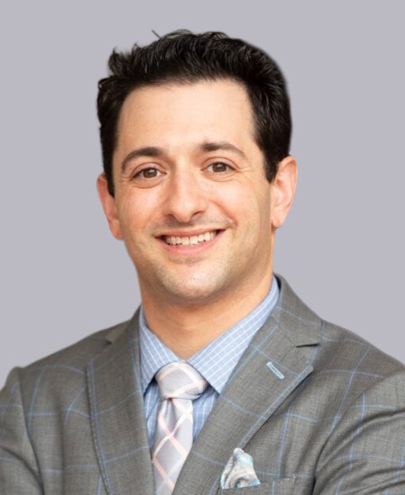 Professional headshot of Dr. Forleiter, MD, FACS, wearing a gray plaid suit with a patterned tie, smiling against a light gray background.