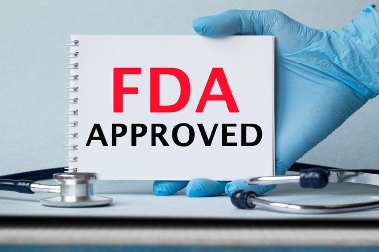 Physician’s hand holding FDA approval sign