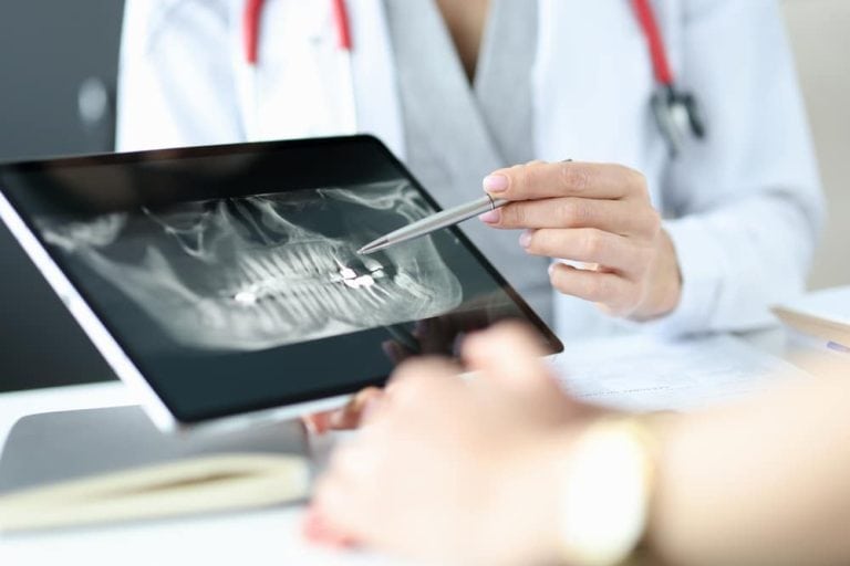 Doctor showing x-ray to patient on tablet